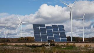 Solar panels on tracking system and windmills in farmland of southwestern Ontario (near Lake Erie), Ontario, Canada.