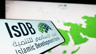 Cellphone with logo of Islamic Development Bank (IsDB) on screen in front of website. Focus on center-left of phone display.