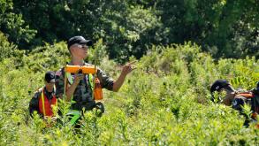 Cadet Tech. Sgt. Mason Gooden, National Ground Search and Rescue School, Civil Air Patrol National Emergency Services Academy, directs fellow students in locating a beacon signal after triangulating the signal to the immediate area at Camp Atterbury, Edin