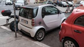 Smart cars in Rome Italy parked in tight spaces.
