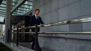 Ambitious businessman leaving office center after successful meeting, routine