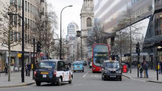 Black cabs, red bus and traffic between offices on Cheapside, City of London, UK