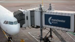 Civil aviation. Commercial air transport. Passenger jet plane connected to its jetbridge on the ramp or apron at Manchester Airport, UK