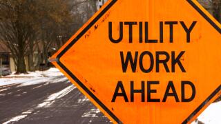 Utility work ahead road construction warning sign.