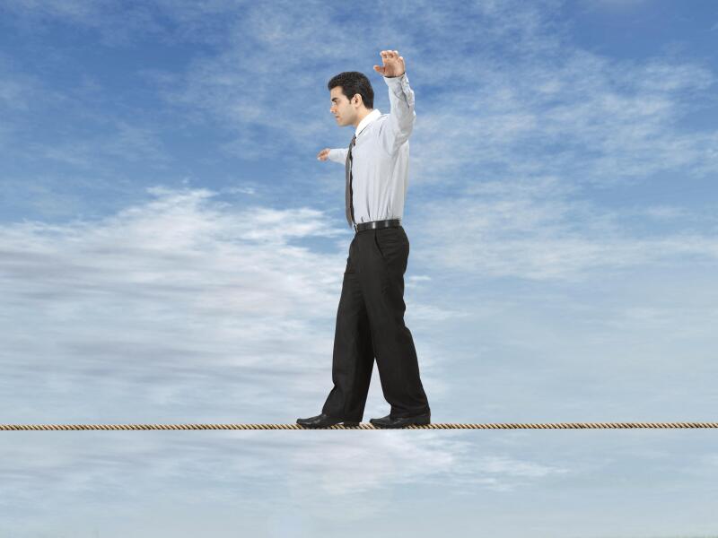 Businessman is balancing on a rope