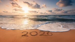 Happy New Year 2026 concept, lettering on the beach. Written text on the sea beach at sunrise.