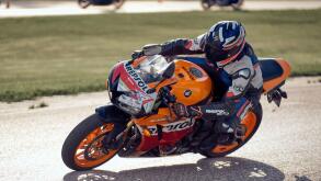 11-05-2020 Riga, Latvia. Motor biker on a race circuit speeding round a corner with a race circuit kerb behind.