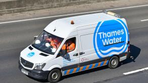 Hard hats & team of workers wear workmen's high visibility safety jackets traveling to work Thames Water logo on side of Mercedes van on UK motorway