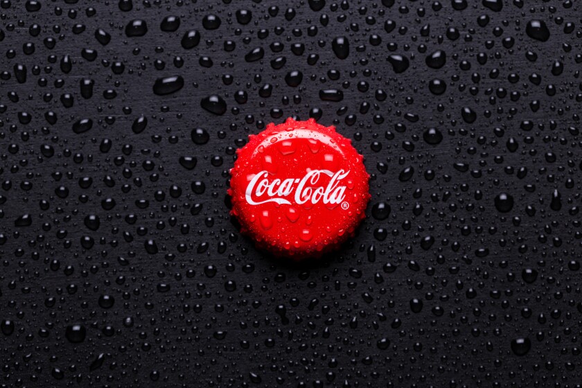 Kiev, UKRAINE - January 28, 2019: classic cap close-up of Coca-cola. Cap of cola on a black background with water drops.