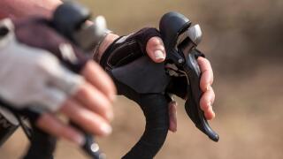 Young woman's hands on the brakes of a road bike