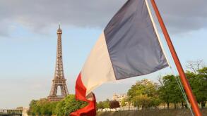 French flag and Eiffel Tower seen from River Seine, Paris, France.