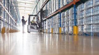 Workers with forklift in bottling warehouse