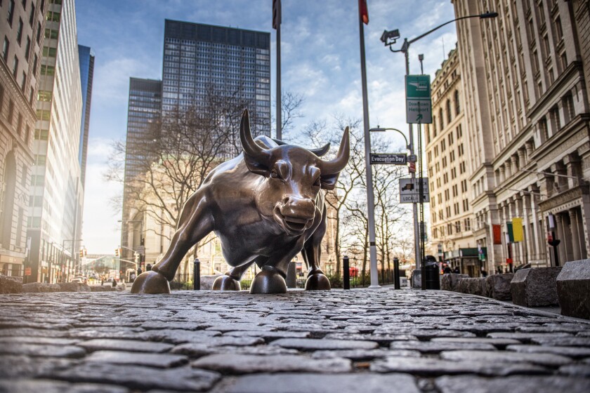 NEW YORK CITY - MARCH 24, 2020: Charging Bull sculpture on March 24, 2020 on empty streets of  New York City during Corona virus Epidemic. 