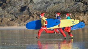 Surfing Santas participate in the annual fund-raising Santa Surfing competition on a very chilly Fistral Beach in Newquay, Cornwall.  UK.