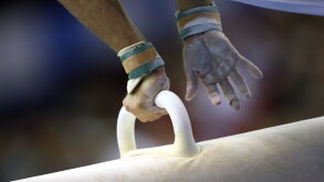 male gymnast competes on pommel horse at a gymnastics competition