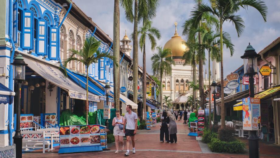 View of colorful Muscat St., lined with traditional shophouses, and Sultan Mosque in Kampong Glam, Singapore; with Asian and Western tourists visiting