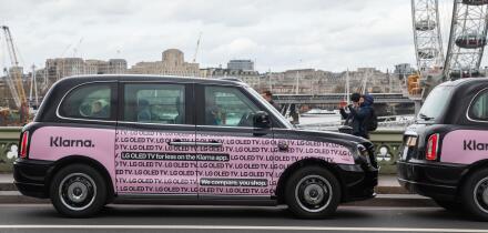 Black taxis with pink Klarna poster in Westminster London, UK