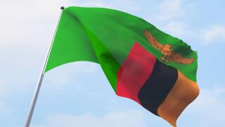 Zambia flag flying on clear sky.