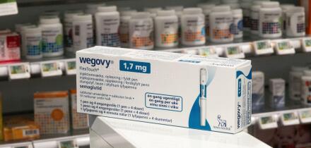 Packaging box of Wegovy (semaglutide) injectable prescription medication, weight-loss drug from Novo Nordisk AS. Pharmacy shop shelves in background.