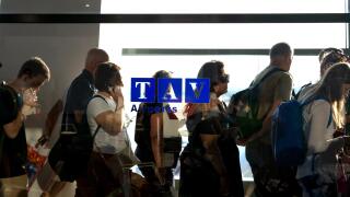 People waiting in line for departure in an airport's hallway