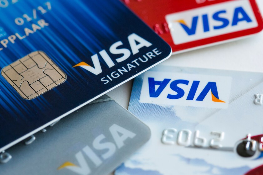 A Visa credit card featuring an EMV chip, also known as "chip and PIN" juxtaposed with a magnetic strip card.