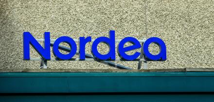A prominent blue sign displays the name of the bank, Nordea, on the exterior of a well-maintained building, emphasizing its modern design and accessib