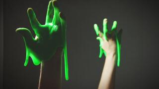 Cropped Hand With Green Slime Against Black Background
