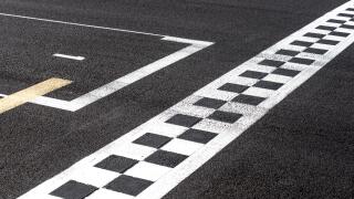 Checkered finish line and pole position sign in motor sport racing track  concept of top number one first position, goal and success
