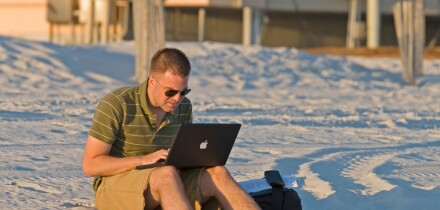 Doing work on computer on the beach