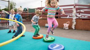 Nursery school children playing in a playground in Warwickshire, UK