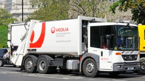 Veolia environmental services hgv tipper truck dustcart rubbish collection commercial vehicle driving along London street in Tower Hamlets England UK
