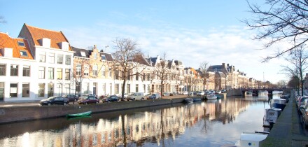 Dutch canal with old houses and boats with blue sky