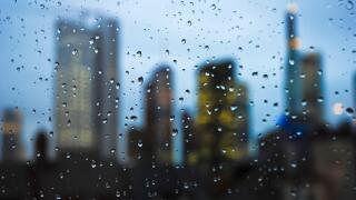 Frankfurt skyline at night seen through a window with rain drops