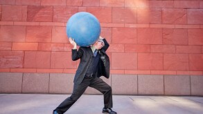 Caucasian businessman carrying heavy ball
