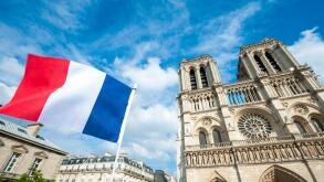 French flag flying in front of Notre Dame Cathedral in Paris, France