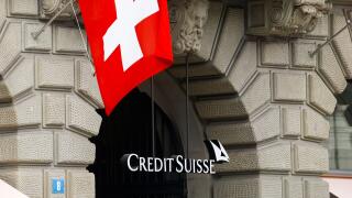 Switzerland's national flag flies above the logo of Swiss bank Credit Suisse at its headquarters in Zurich, Switzerland April 18, 2021. REUTERS/Arnd Wiegmann