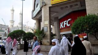 Pilgrims are seen next to 'KFC' (Kentucky Fried Chicken) fast food place located in a shopping mall facing the Great Mosque surrounding the 'kaaba', or the 'Cube', the place towards where hundreds of millions of Muslims around the world pray every day, in