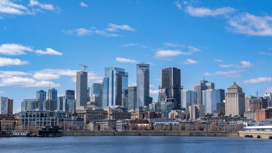 Montreal, Canada - April 4, 2025: A scenic view of Montreal's skyline from the St. Lawrence River, featuring urban architecture against a bright sky