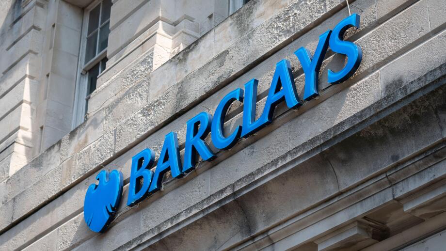 Large sign outside a branch of Barclays Bank in a city, UK.