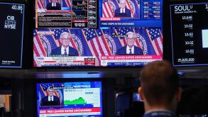 Screens on a trading post on the floor of the New York Stock Exchange show the news conference of Federal Reserve Chair Jerome Powell, Wednesday, May 7, 2025. (AP Photo/Richard Drew)
