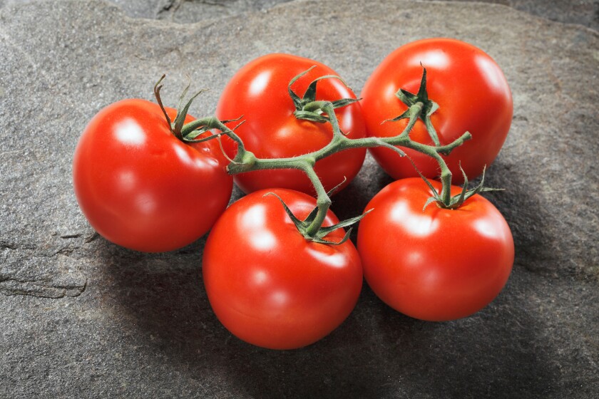 Fresh ripe tomatoes on stone background