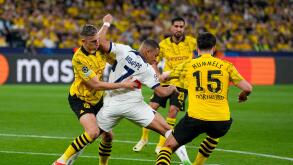PSG's Kylian Mbappe, center, is challenged by Dortmund's Nico Schlotterbeck, left, and Mats Hummels during the Champions League semifinal first leg soccer match between Borussia Dortmund and Paris Saint-Germain at the Signal-Iduna Park in Dortmund, German