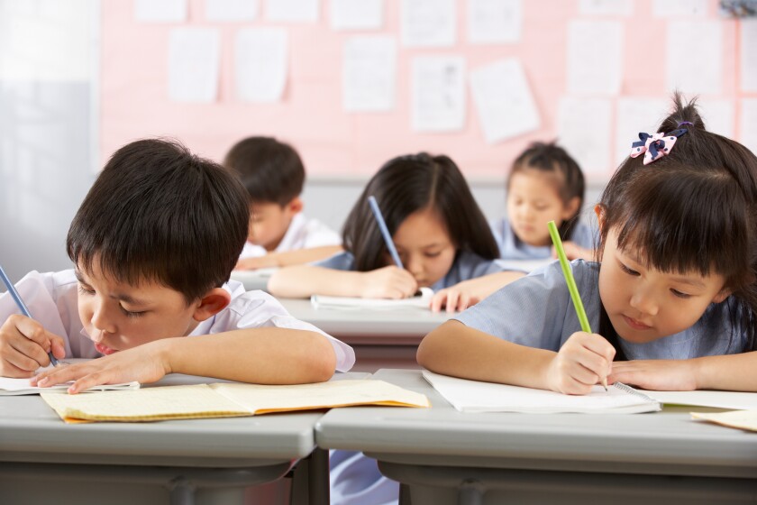 Group Of Students Working At Desks In Chinese School Classroom-adobe-2022