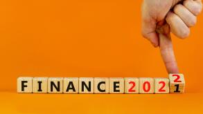 2022 finance and new year symbol. Businessman turns wooden cubes, changes words 'finance 2021' to 'finance 2022'. Beautiful orange background, copy sp