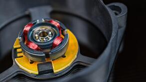 Electric motor rotor with permanent magnet, copper wire inductors and metal ball bearing. Disassembled computer fan with integrated Hall-effect sensor.