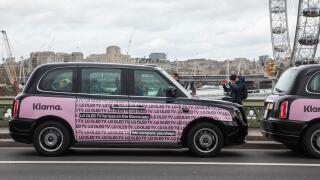 Black taxis with pink Klarna poster in Westminster London, UK