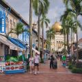 View of colorful Muscat St., lined with traditional shophouses, and Sultan Mosque in Kampong Glam, Singapore; with Asian and Western tourists visiting