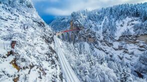 Bernina Express passes through the snowy woods around Filisur Canton of Grisons Switzerland Europe