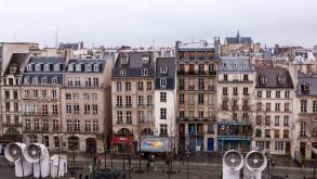 Paris houses roof in a rainy day from the windows of the Centre Georges Pompidou with drops of water in glass.