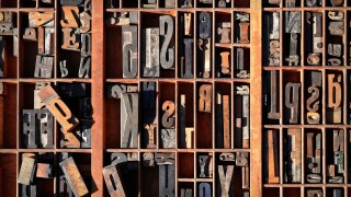 A box of old vintage printing press letter blocks in a old wooden box